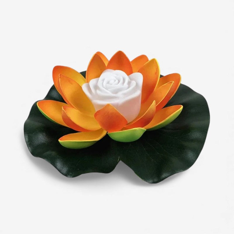 Lotusformad flytande lampa med orange kronblad på ett mörkgrönt blad och vit mitt 3