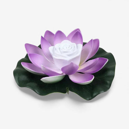 Lotusformad flytande lampa med lila kronblad på ett mörkgrönt blad och vit mitt 2