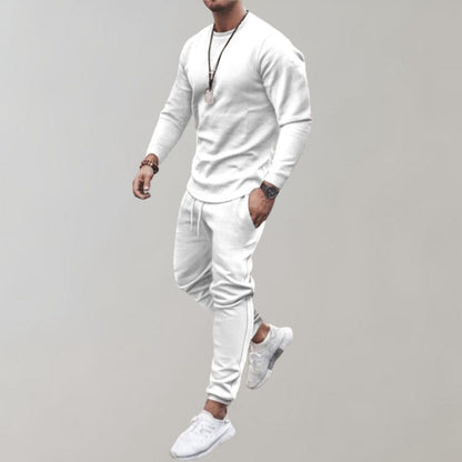 Mann in weißem Trainingsanzug, Langarmshirt, Jogginghose, Sneakers, sportlich, modern.