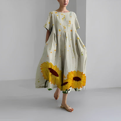 Frau in grauem Maxikleid mit Sonnenblumenmuster, Sommermode, lässig, elegant.