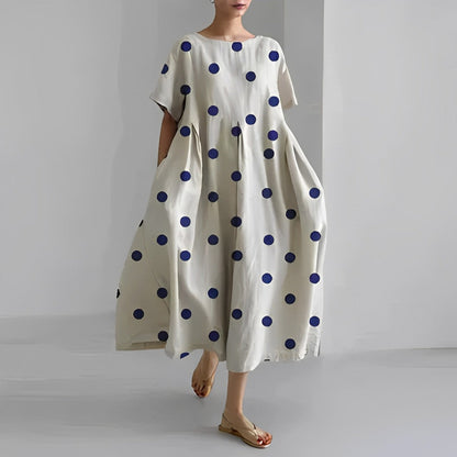 Frau in weißem Kleid mit blauen Punkten, Sommermode, lässig, knöchellang, Kurzarm.