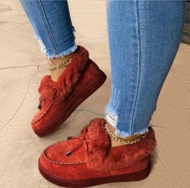 Rote Damen-Winterschuhe mit Fell, bequem, modisch, getragen mit blauen Jeans.