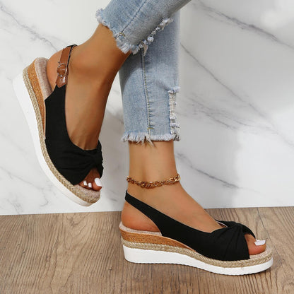 Schwarze Damen-Sandalen mit Keilabsatz, bequem, Sommermode, Jeanshintergrund.