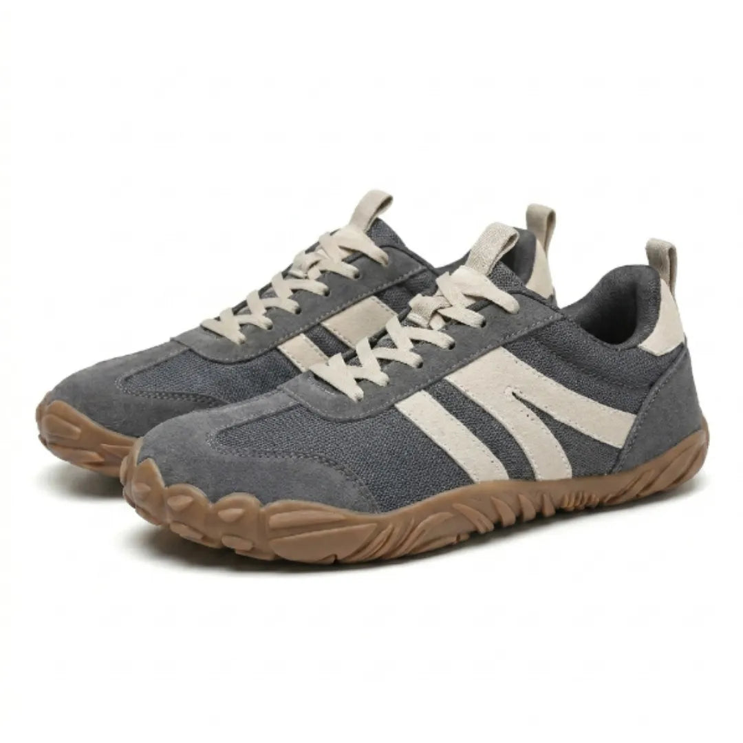 Ett par grå skor med beige ränder och brun gummisula snett framifrån på vit bakgrund. 7