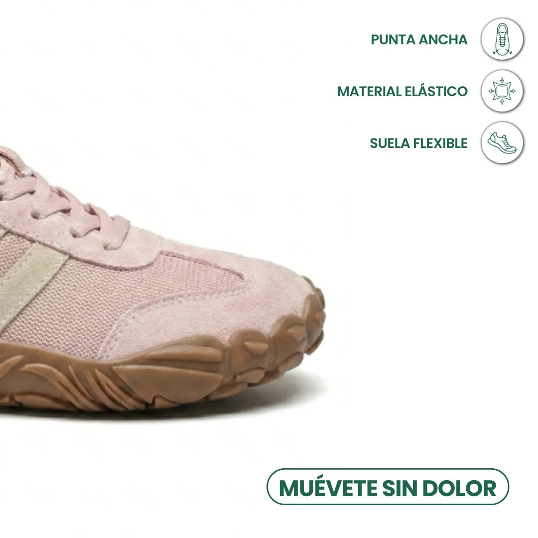 Närbild på tåpartiet av rosa sko med brun, flexibel sula och ikoner över bred tåbox och elastiskt material. 14