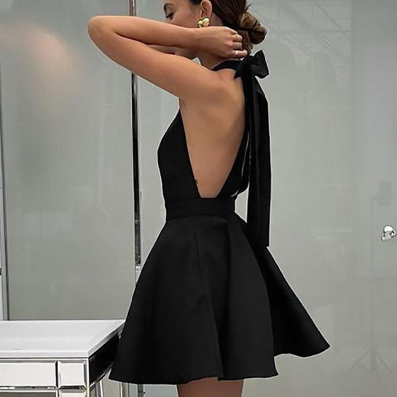 Frau im schwarzen Satin-Cocktailkleid mit Schleife, ärmellos, elegantes Abendoutfit.