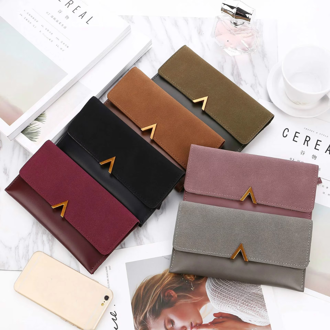 Lange Damen-Geldbörsen aus Samt und Leder in verschiedenen Farben auf Marmortisch.