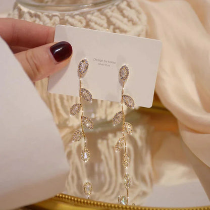 Lange goldene Ohrringe mit Kristallblättern, eleganter Schmuck, Design aus Korea.