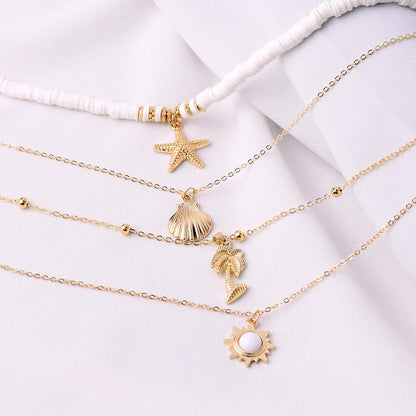 Goldene Halsketten mit Muschel- und Sternanhängern auf weißem Hintergrund, Modeschmuck.