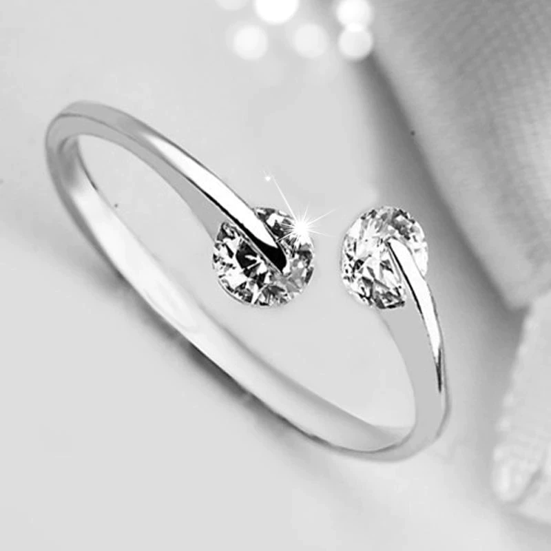 Silberner Verlobungsring mit zwei funkelnden Diamanten, elegantes Schmuckdesign.