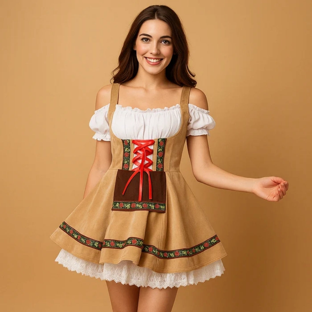 Leende kvinna i beige dirndl med rött snörband, brunt förkläde, blommigt bandverk och vit spetsunderkjol som syns under kjolen. 3