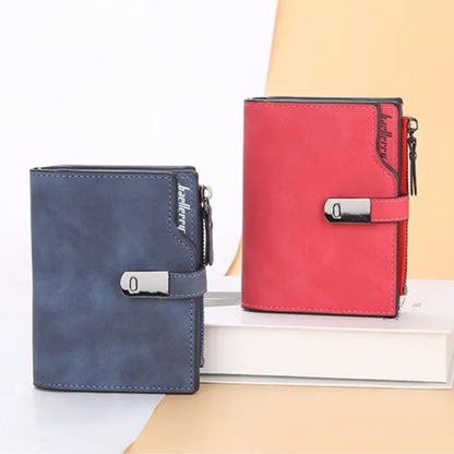 Zwei magnetische Kurzgeldbörsen, blau und rot, mit Schnalle, aus Leder, auf weißem Hintergrund.