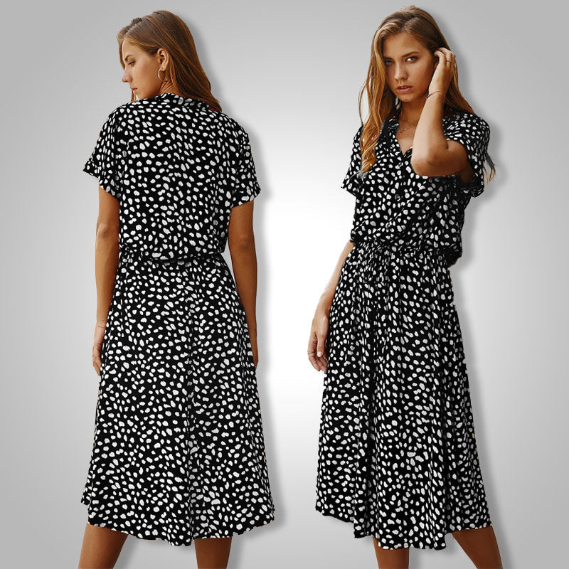 Frau in schwarz-weiß gepunktetem Kleid, Sommermode, knielang, kurzärmelig, elegant.