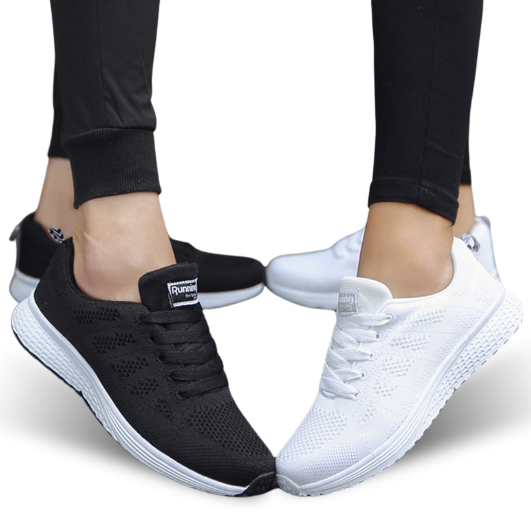 Schwarze und weiße Sportschuhe, atmungsaktiv, für Damen, auf weißem Hintergrund.