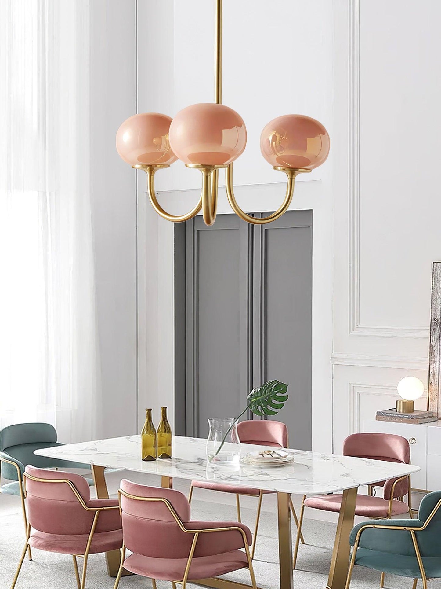 Rosa Kronleuchter aus Glas und Metall über Marmortisch in modernem Esszimmer.