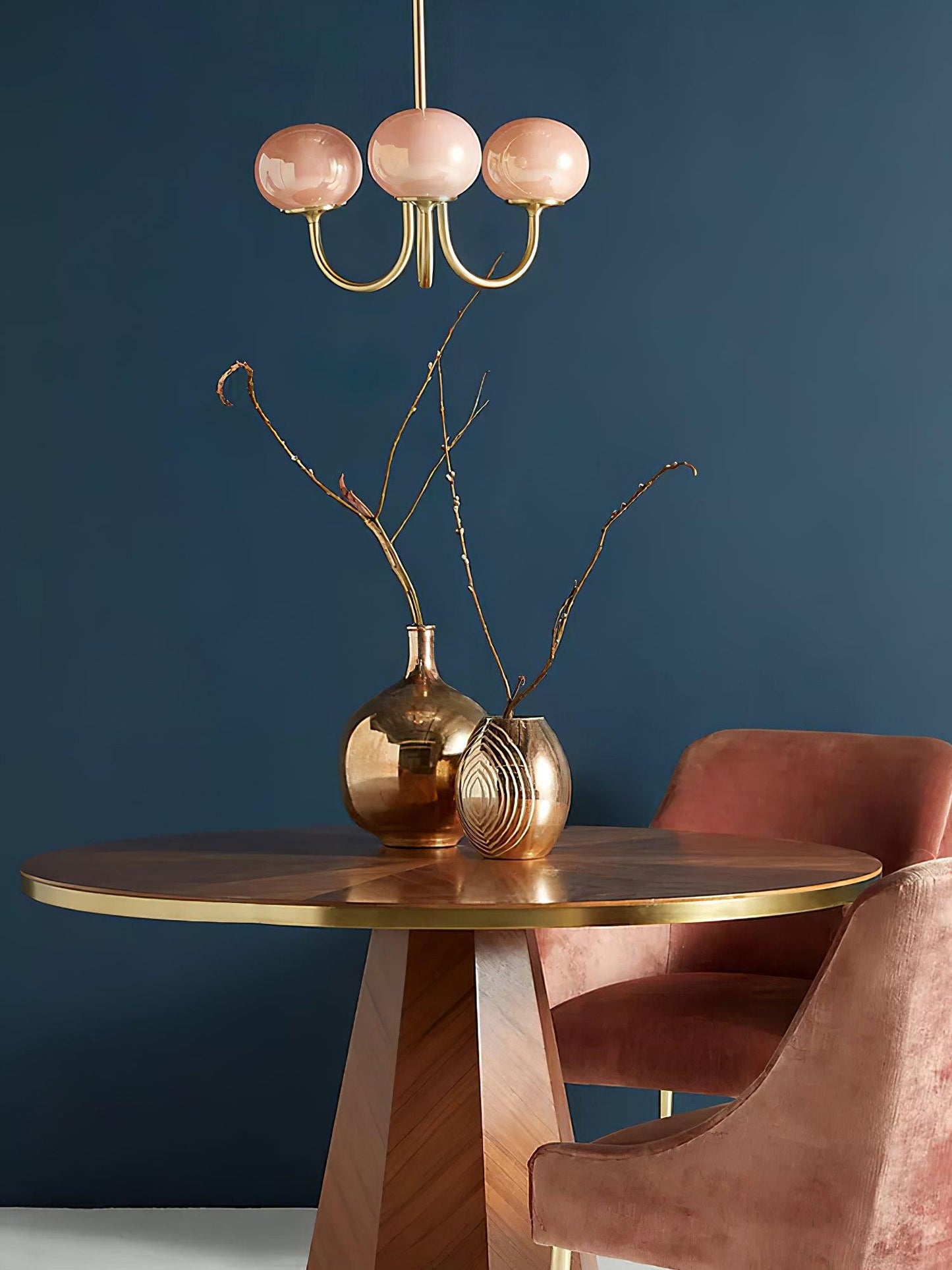 Rosa Kronleuchter über Holztisch, goldene Vasen, rosa Stuhl, modernes Wohnzimmerdesign.