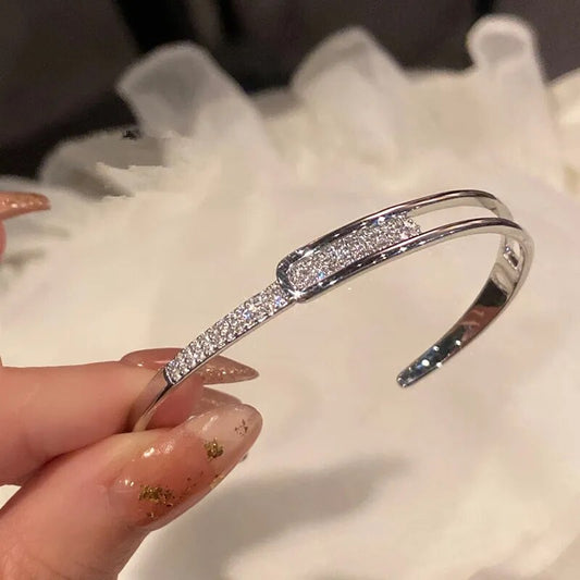 Silbernes Armband mit Strasssteinen, elegantes Design, Schmuck für Damen, modisch und glänzend.