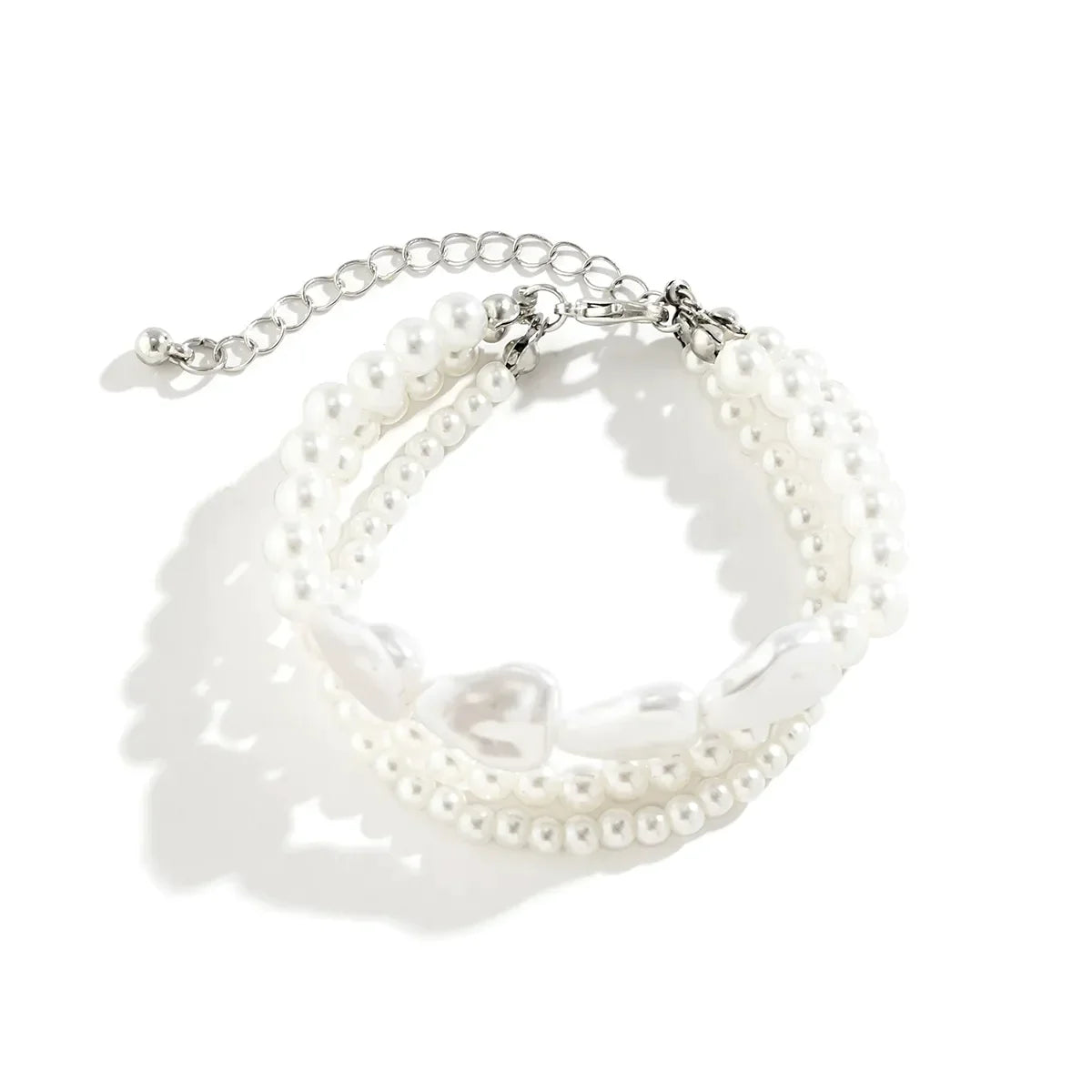 Dreireihiges Armband aus weißen Perlen mit verstellbarem Verschluss, eleganter Schmuck.