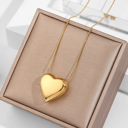 Goldenes Herz-Halskette auf beigem Schmuckkästchen, elegantes Design, Geschenkidee.