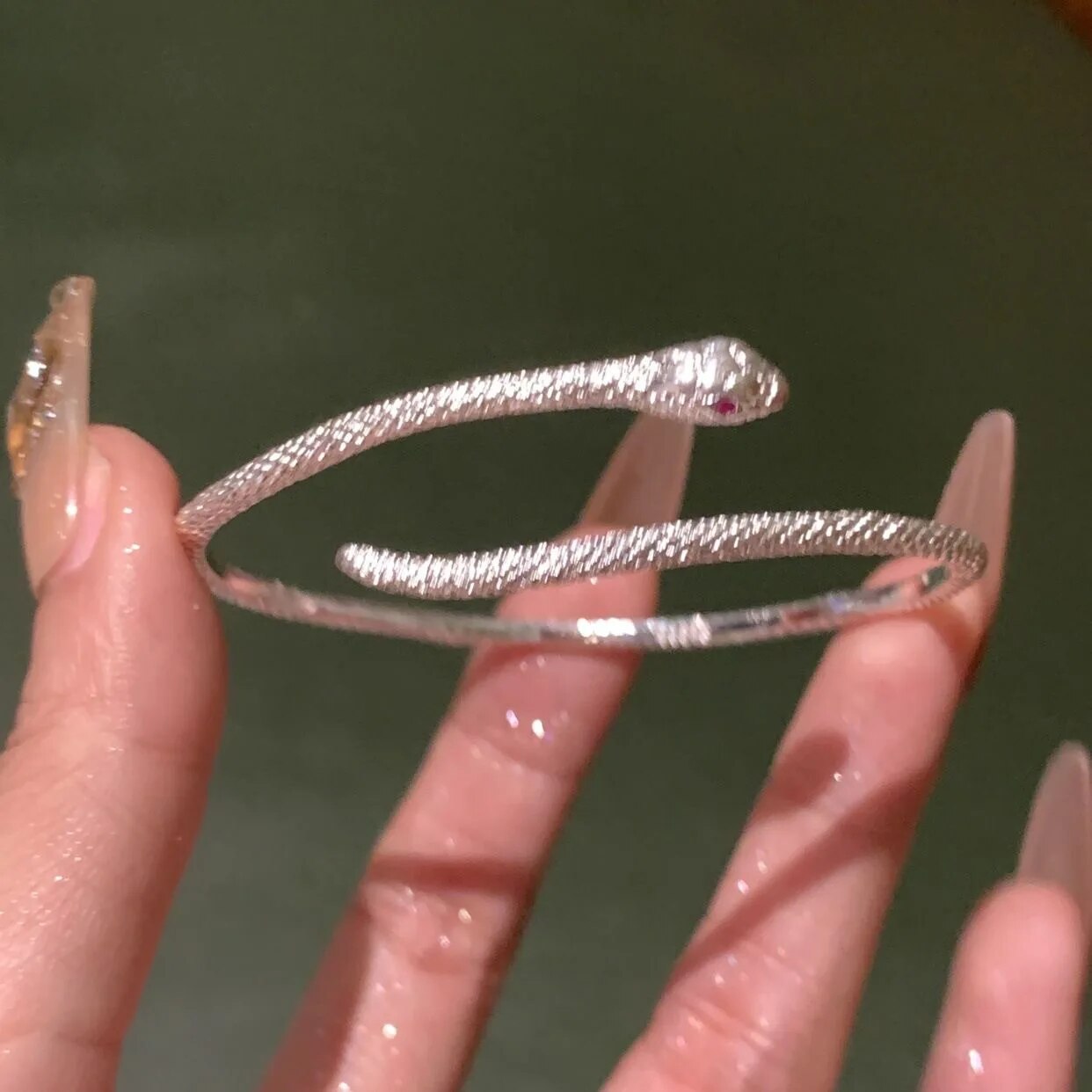 Silbernes Schlangenarmband, funkelnd, elegantes Design, Damenmode-Schmuck, luxuriös.