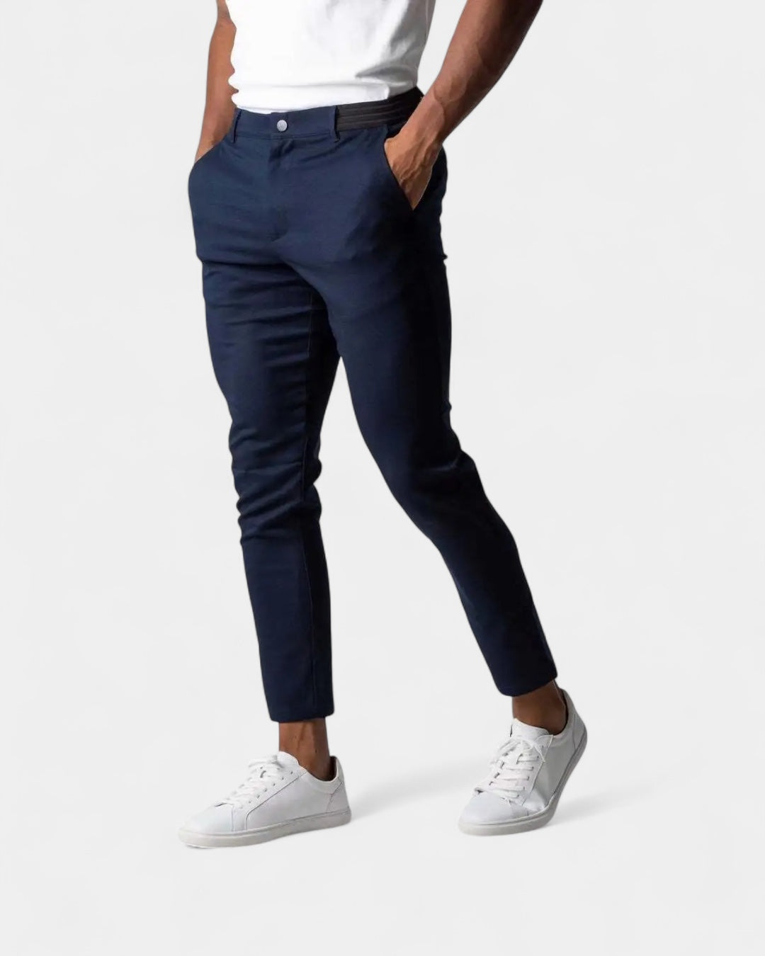 Man bär mörkblå byxor med svart resårlinning, vit t-shirt och vita sneakers 2