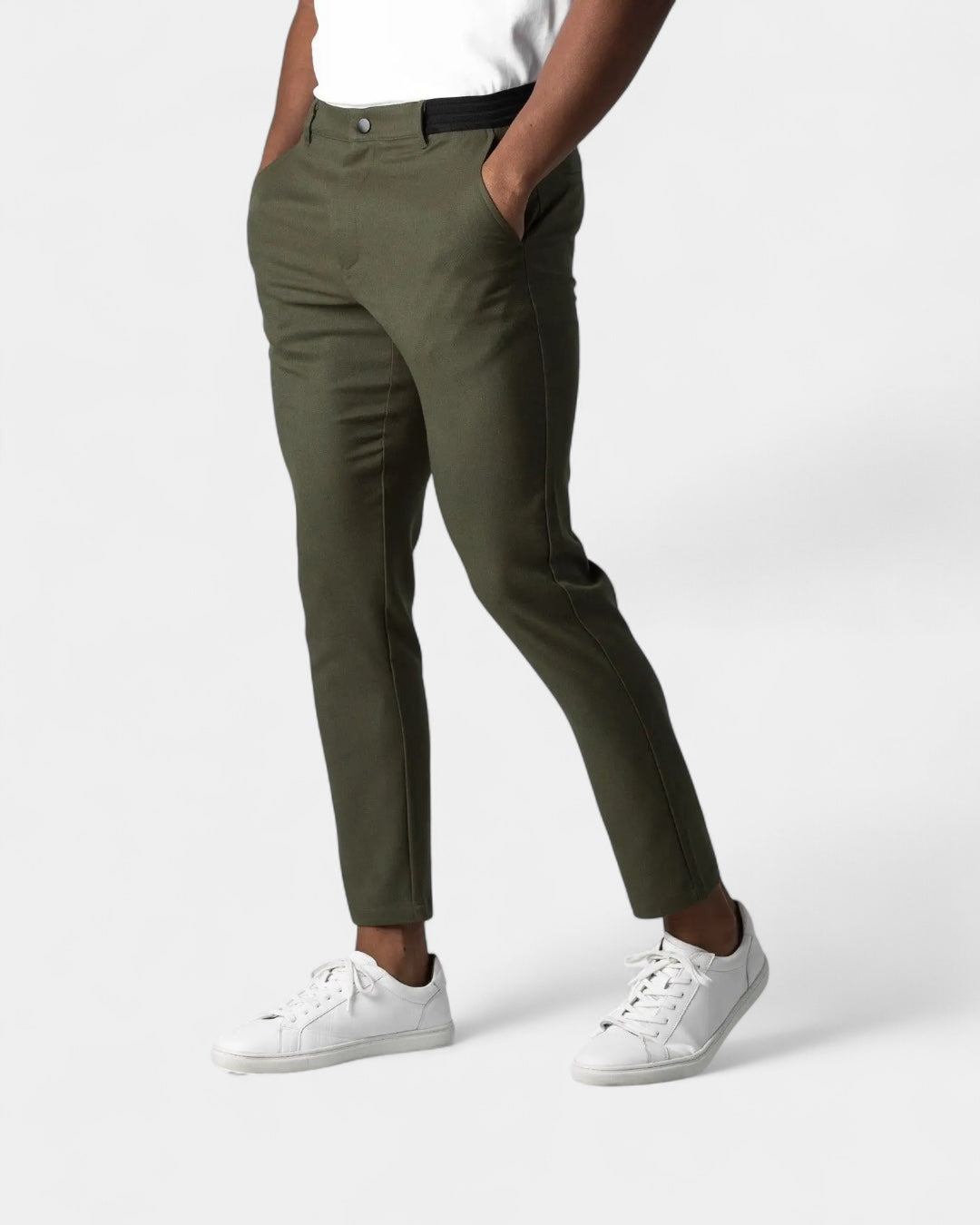 Man bär mörkgröna byxor med svart resårlinning, vit t-shirt och vita sneakers 4