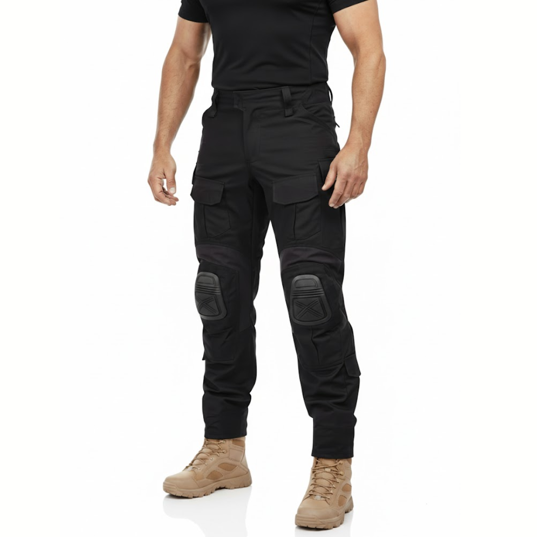 Man i svart tröja och beige kängor bär de svarta byxorna, sedd snett framifrån med knäskydd och lårfickor. 2