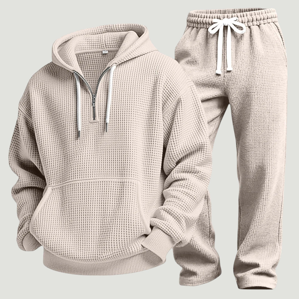 Beige set av våffelstickad huvtröja med halv dragkedja och joggingbyxor med vitt dragsnöre, fristående produktbild. 8