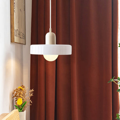 Moderne weiße Glas-Pendelleuchte vor braunem Vorhang, stilvolle Innenbeleuchtung.