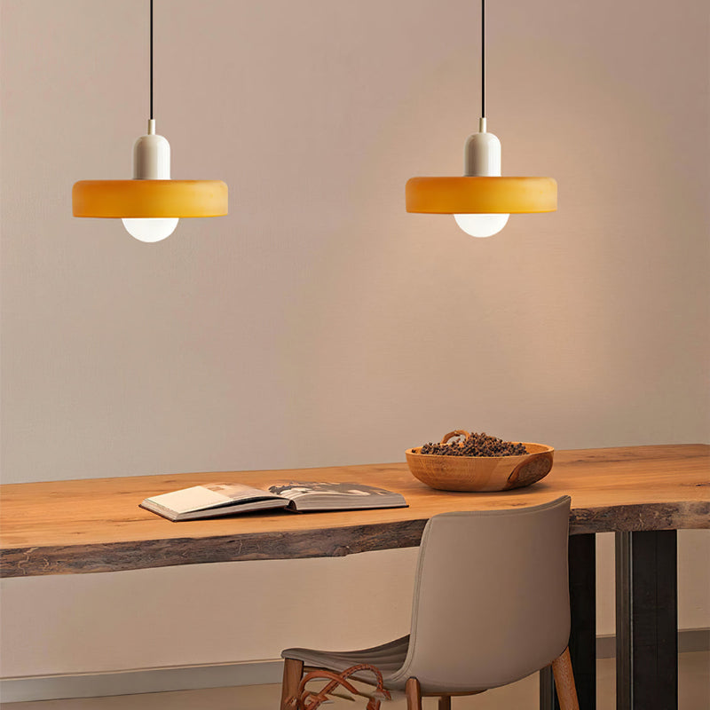 Moderne bunte Glas-Pendelleuchte, orange, über Holztisch, skandinavisches Design.