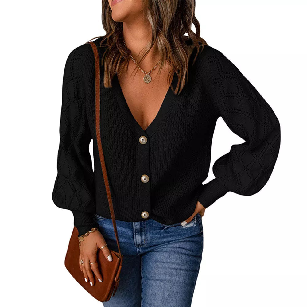 Frau in schwarzem Strickcardigan mit Knöpfen, Jeans und brauner Umhängetasche.