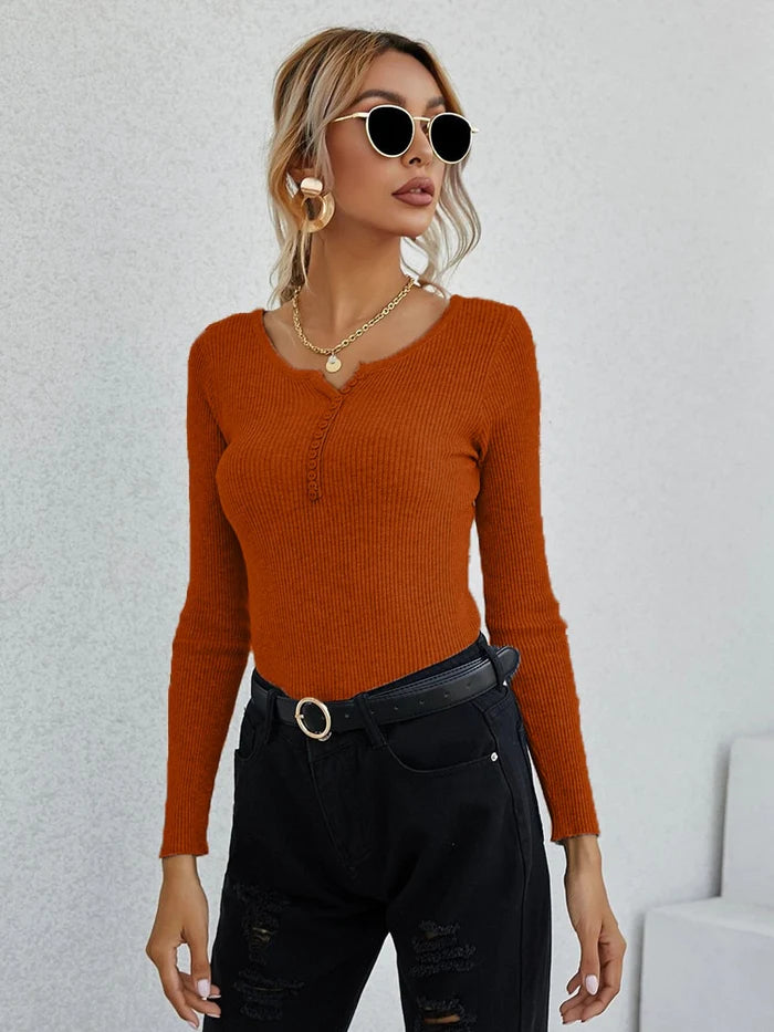 Frau in orangefarbenem V-Ausschnitt-Pullover, schwarze Hose, modisch, elegant, Damenmode.