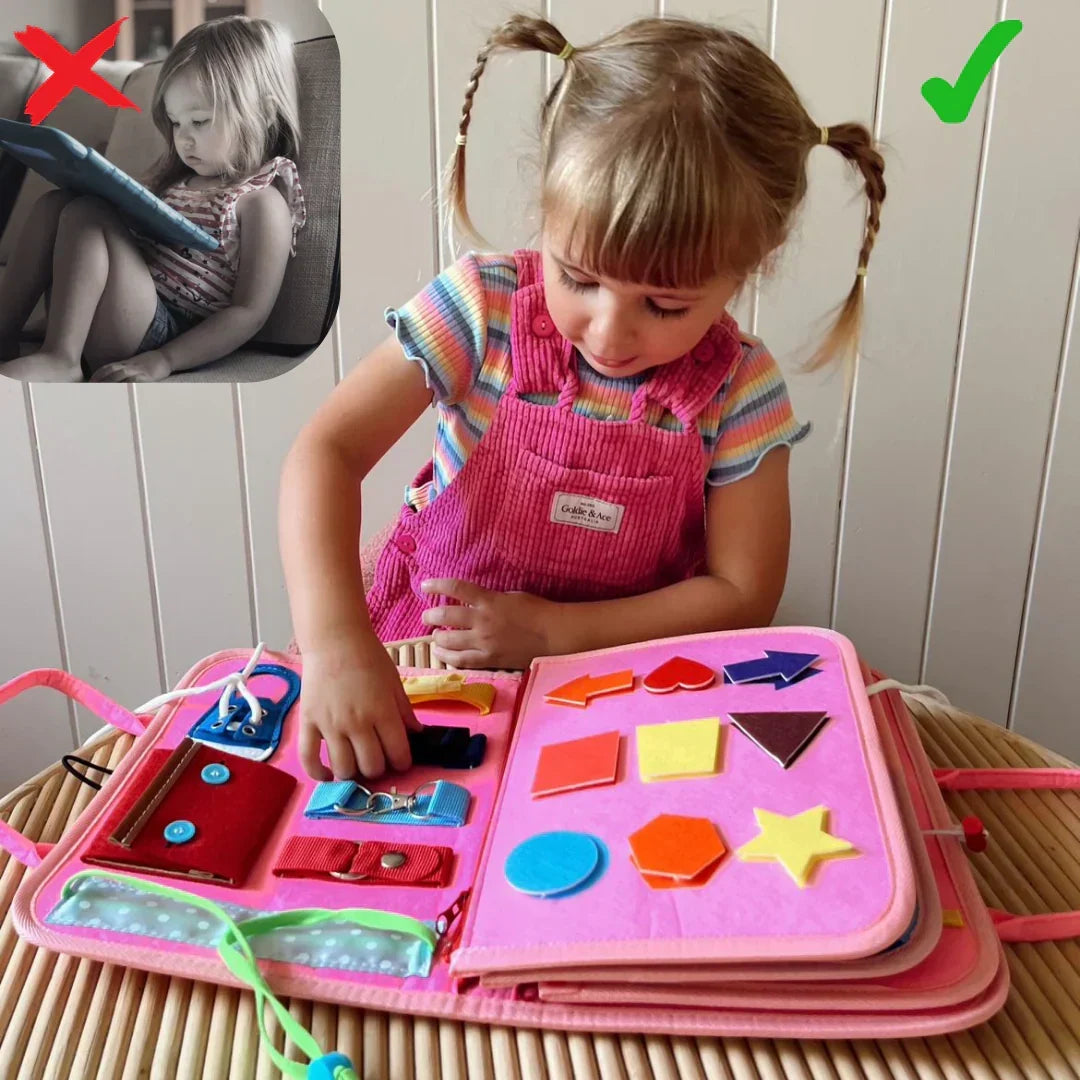 Flicka med flätor undersöker den rosa boken med former, spännen och snörning på bordet 4