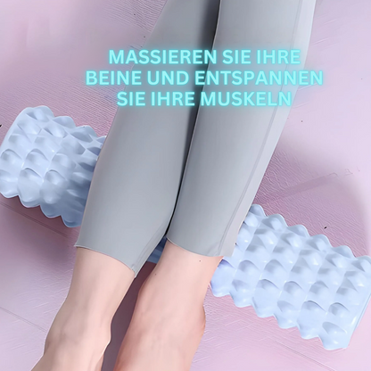 Frau mit grauer Leggings auf blauer Schaumstoffrolle, Muskelentspannung, Fitnessgerät.