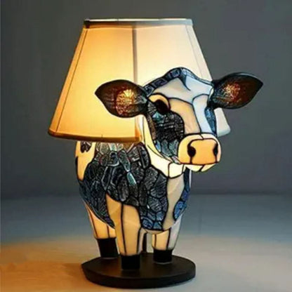 Lampa med kupformad lampskärm och en ko i blå och vit mosaikstil på en rund svart bas. 12