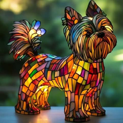 Hundlampa med lång slingrande päls och yvig svans i färgat glas, lysande i varma toner på ett bord med grön bakgrund. 28