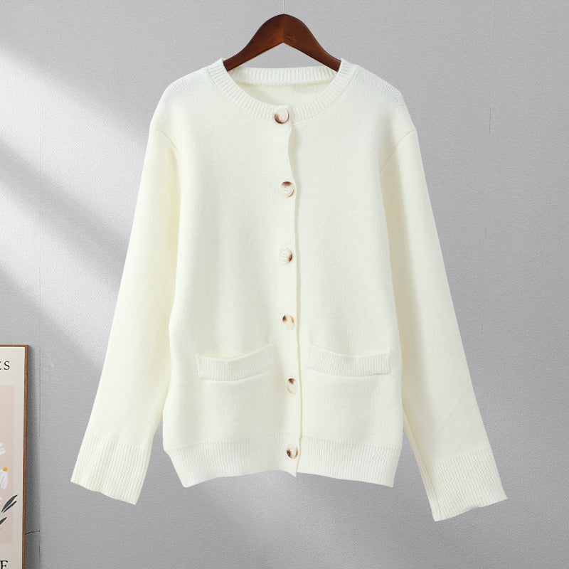 Beiger Button-Up-Pullover, weiches Material, Damenmode, lange Ärmel, hängend auf Holzkleiderbügel.