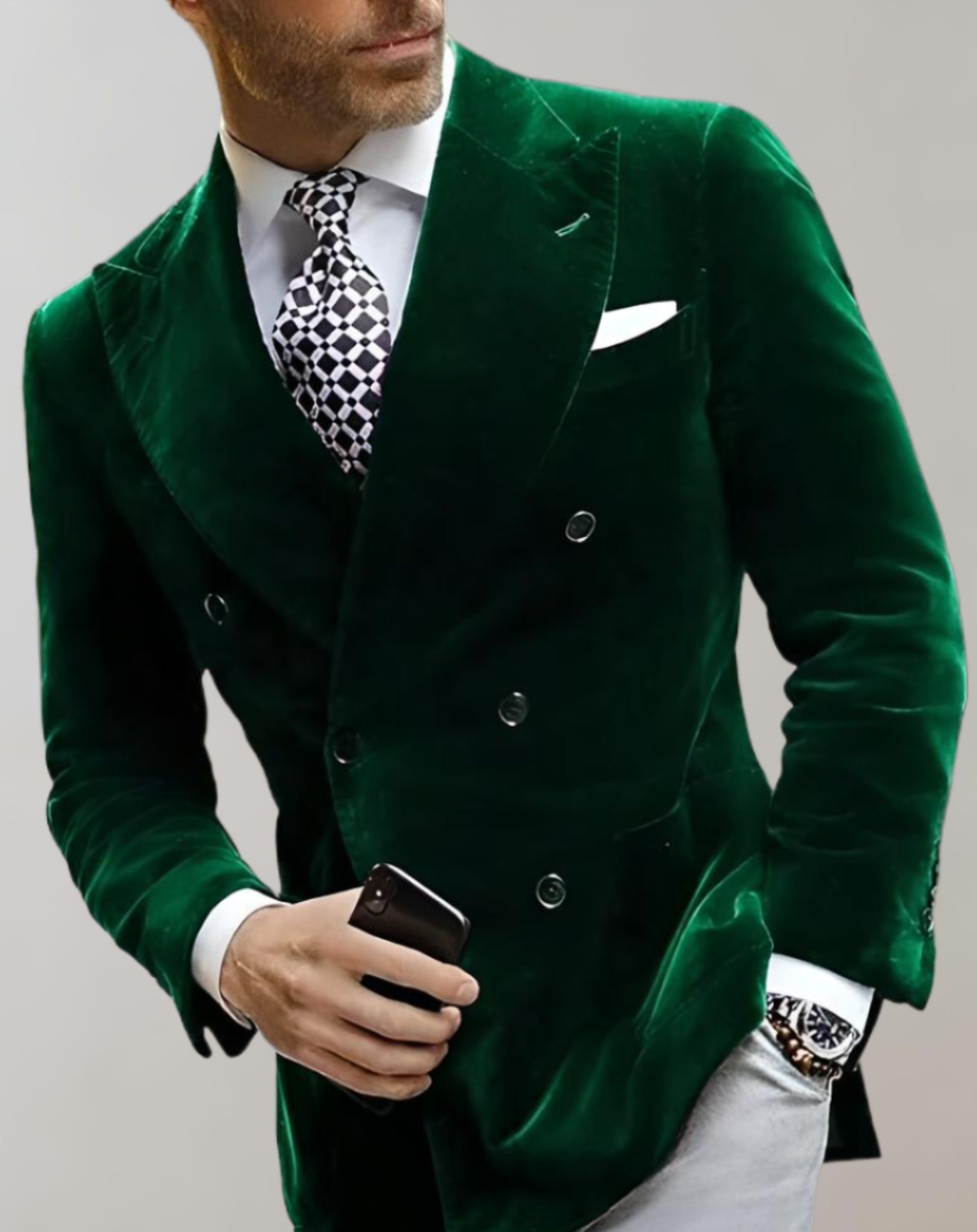 Mann im grünen Samtanzug mit Krawatte, hält Smartphone, eleganter Herrenmode-Look.
