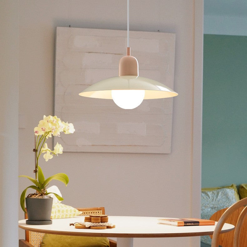 Pendellampa med gräddvit skärm och rosa topp ovanför ett runt matbord med orkidé 2