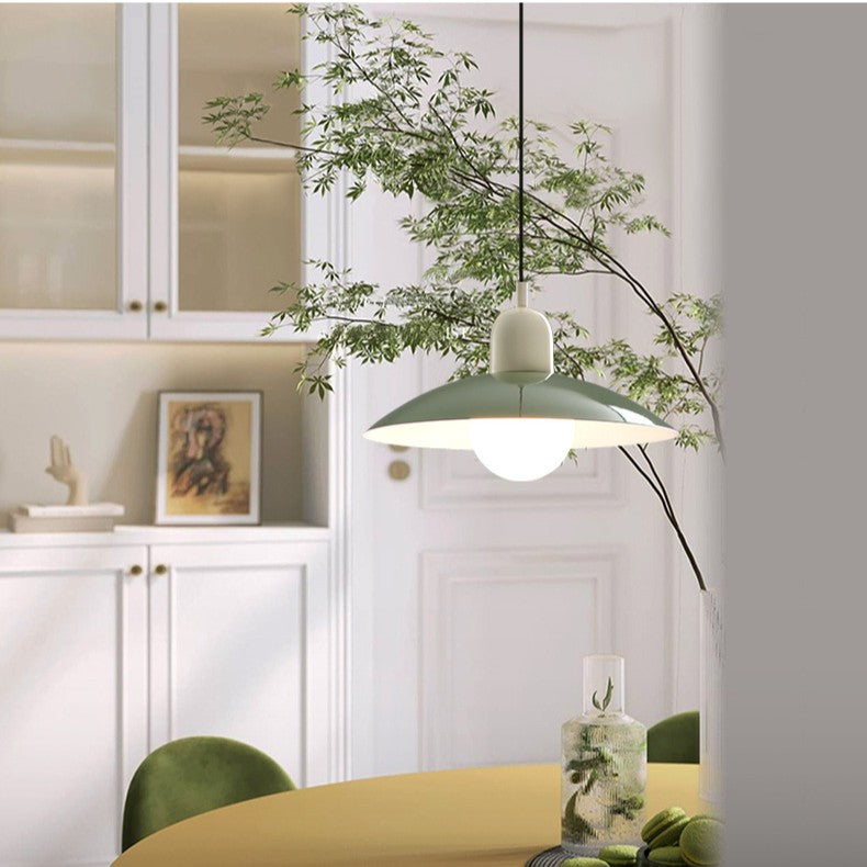 Pendellampa med grön skärm och vit topp i ett matrum med gröna stolar och grenar 7