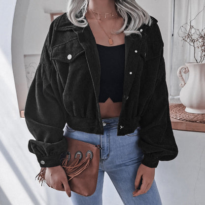 Frau in schwarzer Cordjacke, blauer Jeans, brauner Tasche, modisch, lässiger Stil.