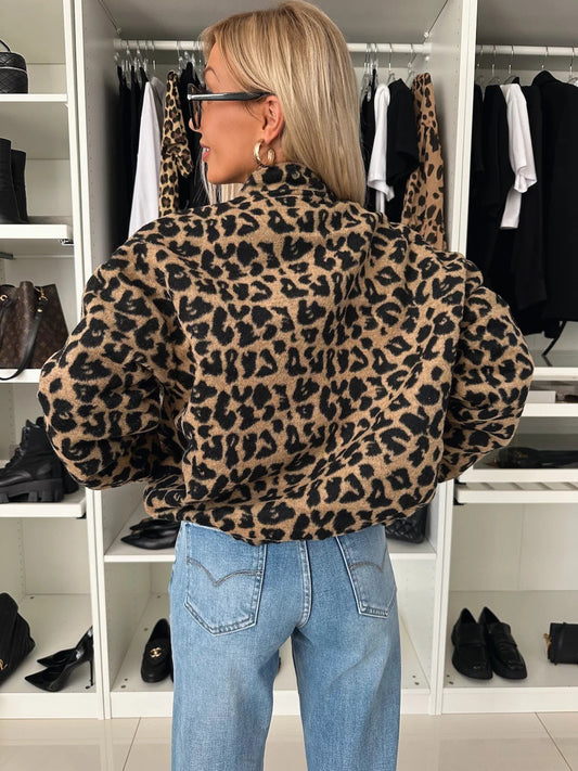 Jackan sedd bakifrån på en modell, med leopardmönstret över ryggen, ballongärmar och resår nedtill, burna med ljusblå jeans. 2