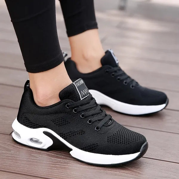Schwarze Damen-Sneaker, atmungsaktiv, mit weißer Sohle, ideal für Sport und Freizeit.