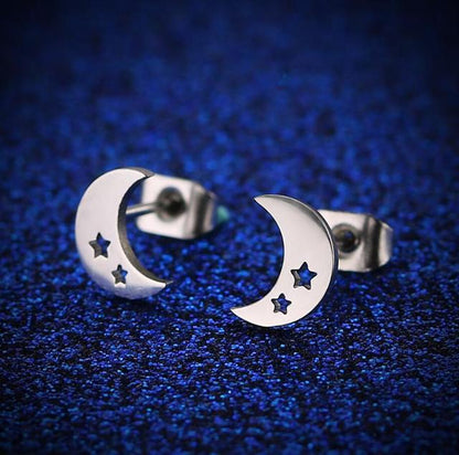 Silberne Edelstahl-Ohrringe mit Mond- und Sternmotiv auf blauem Hintergrund.
