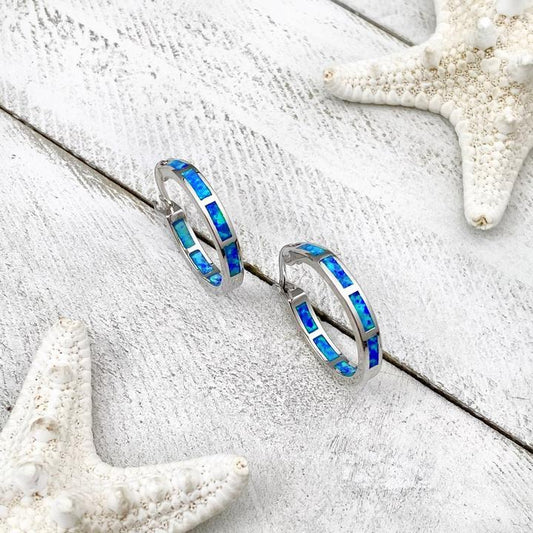Opal Creolen Ohrringe mit blauen Steinen, silber, auf weißem Hintergrund, Schmuck Accessoire.