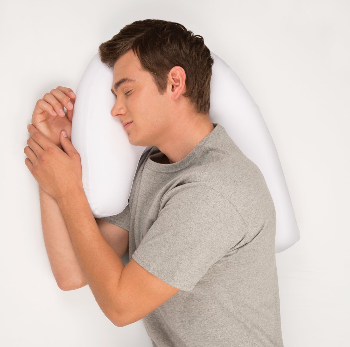 Mann schläft auf weißem orthopädischen Kissen, ideal bei Nacken- und Rückenschmerzen.