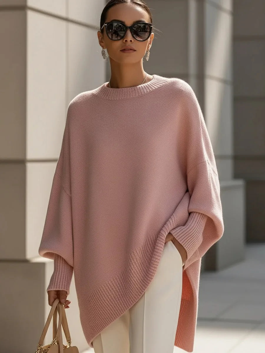 Modell bär den rosa versionen av tröjan med ribbad asymmetrisk nederkant, vita byxor och solglasögon. 11