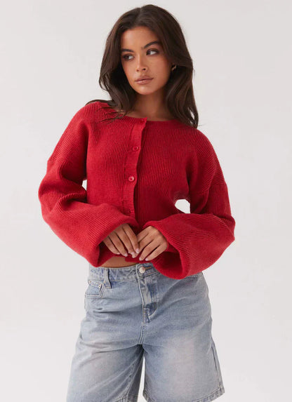 Frau trägt roten Strick-Cardigan und Jeansshorts, modische Damenbekleidung, lässiger Stil.