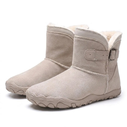 Ett par ljusbeige mockakängor med fleecefoder, sidospänne och bred gummisula, snett framifrån 34
