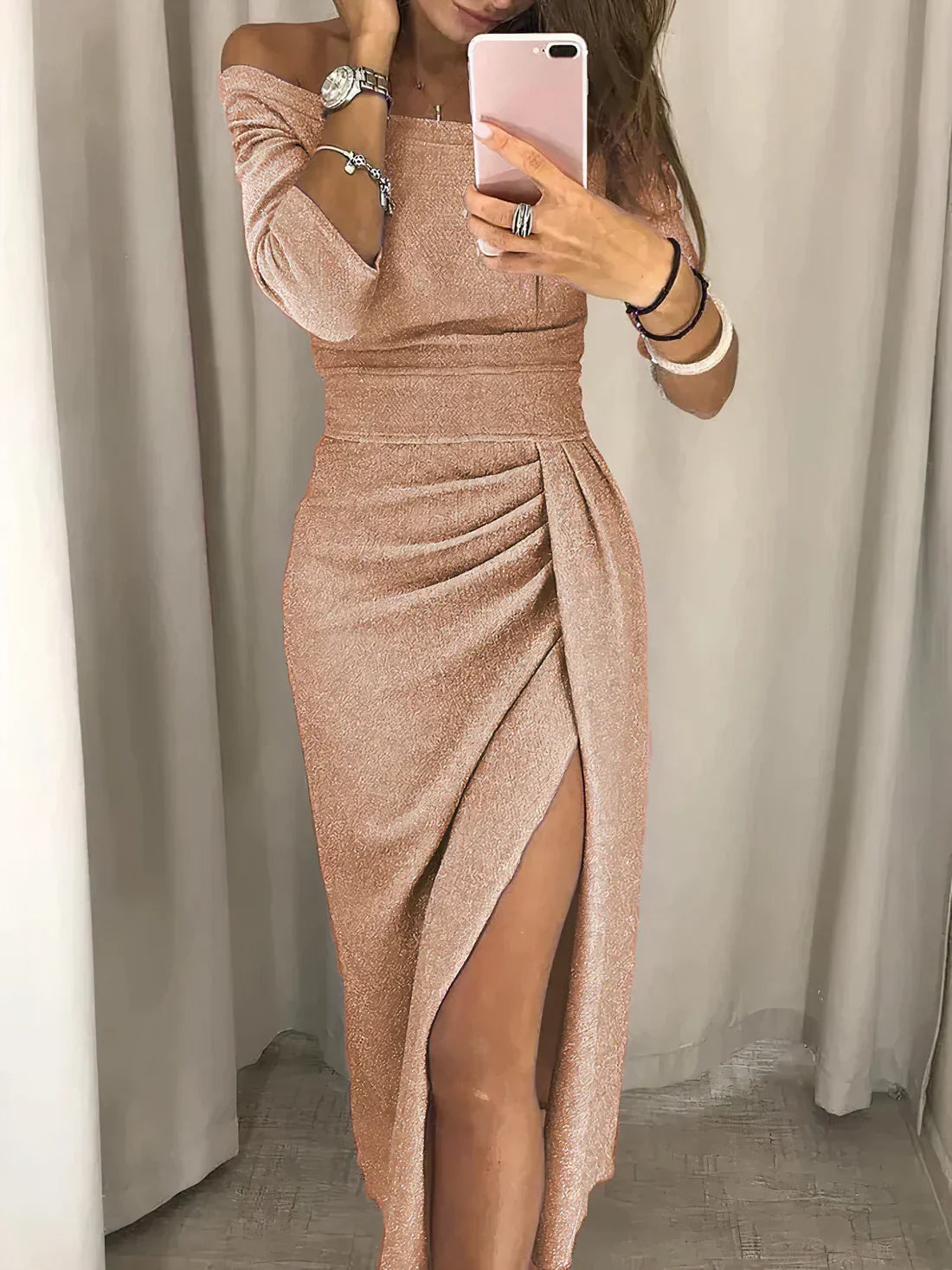 Frau im rosa schulterfreien Abendkleid mit hohem Schlitz, elegantes Design, Handy in der Hand.